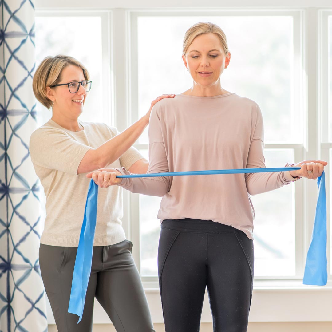Jess working with a client and exercise bands | Full Circle Wellness | Physical Therapy & Health Coaching | Orthopaedic Injury | Pain Management | Injury Prevention | Sports Medicine | Wellness Assessments | Nutrition & Weight Loss | Newbury, MA